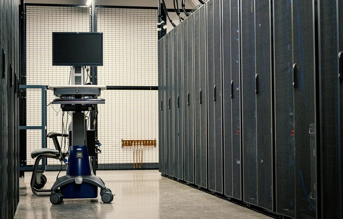Rzędy szaf serwerowych w serwerowni z konsolą diagnostyczną