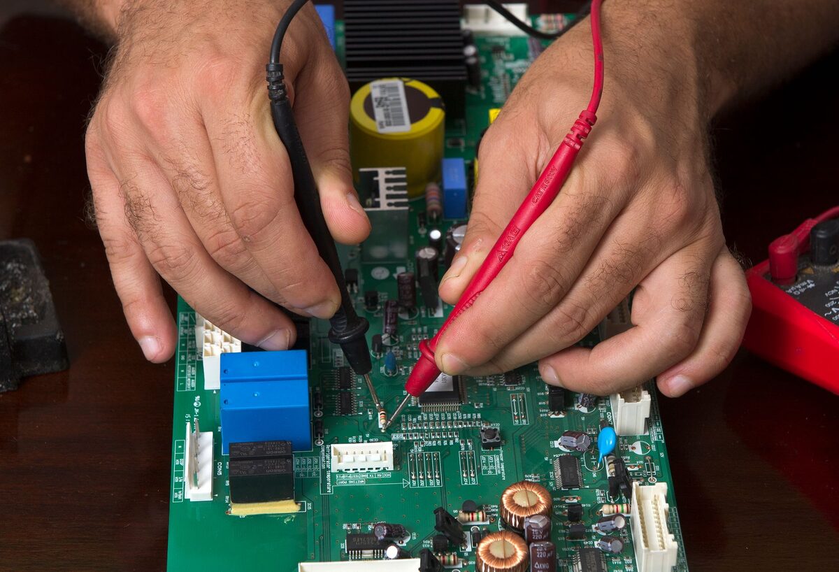 Pomiar sondami multimetru na płycie elektroniki podczas bezpłatnej diagnozy