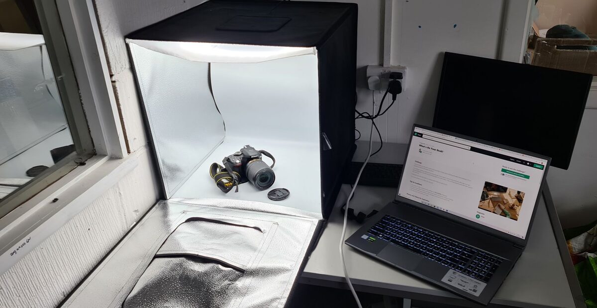 Namiot bezcieniowy do fotografii produktowej obok laptopa