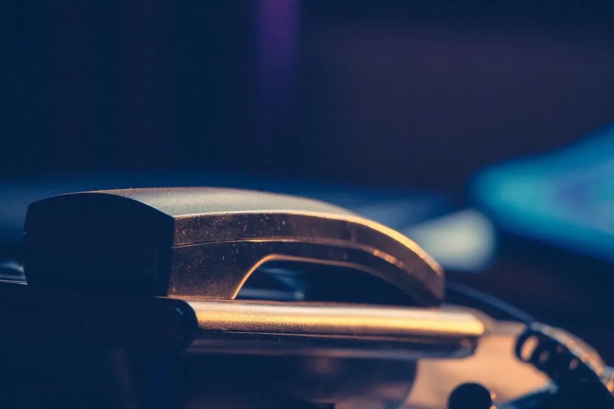 Słuchawka telefonu stacjonarnego w półmroku — komunikacja w trakcie trwania naprawy