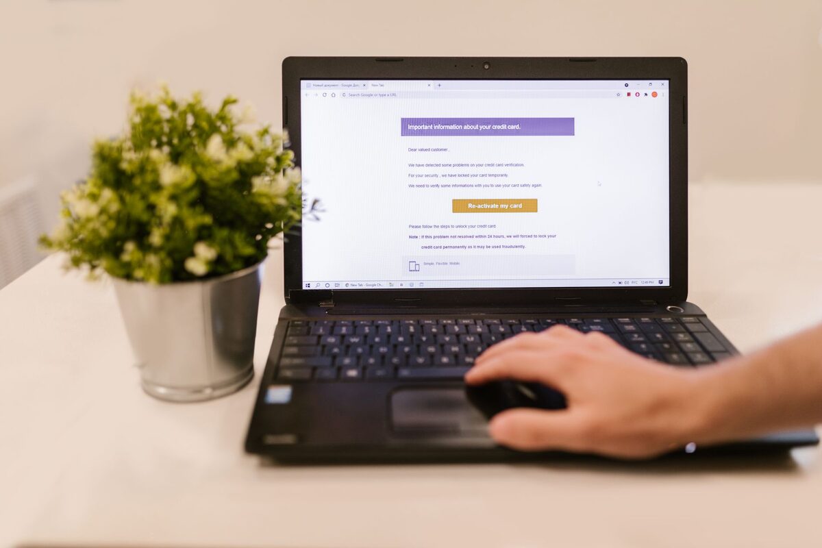 Dłoń przy laptopie z ekranem logowania do poczty