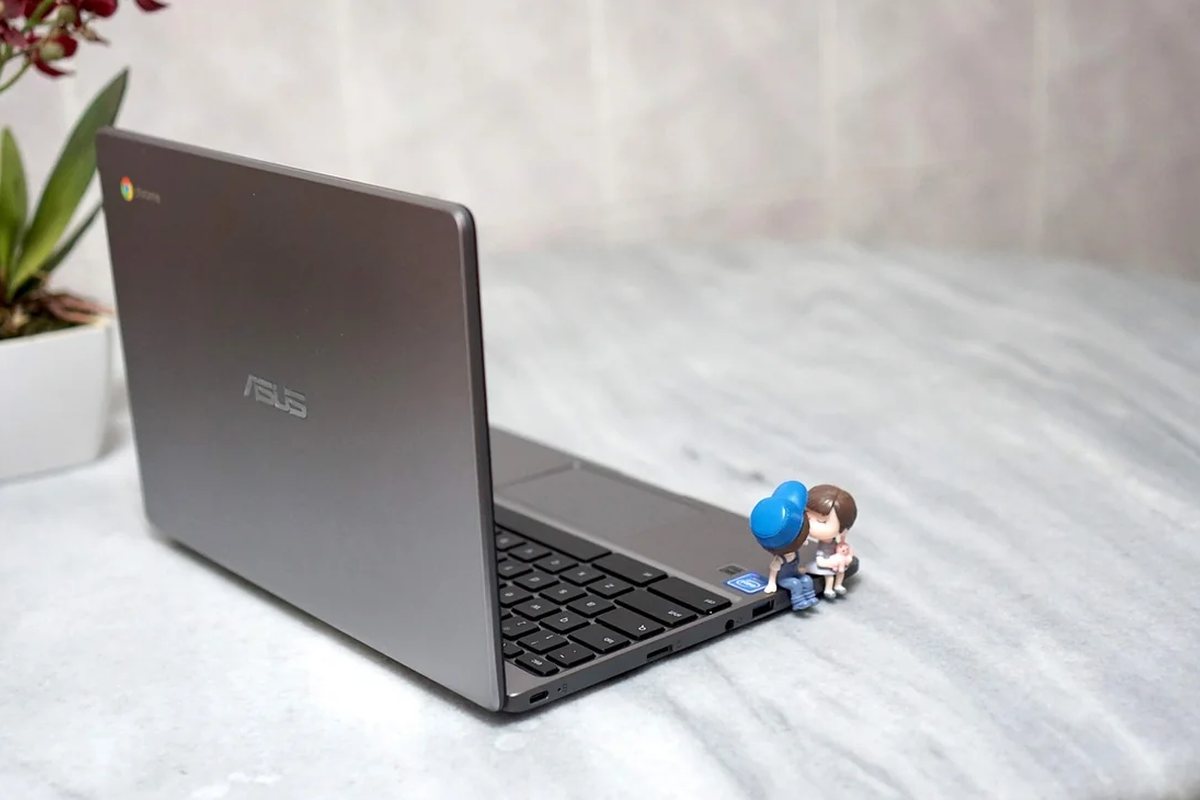 Szary laptop ASUS na jasnym kocu — laptop zastępczy na czas naprawy