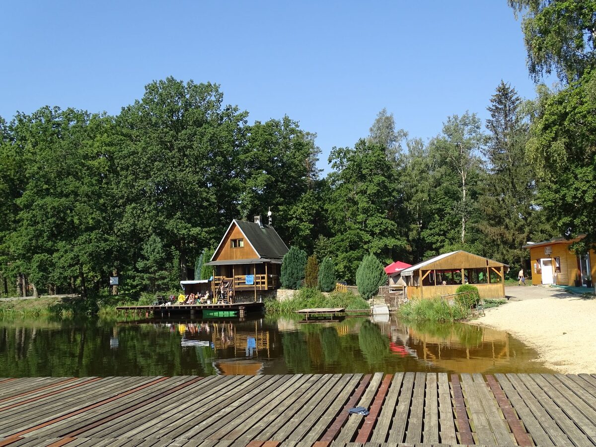 Drewniany domek letniskowy nad wodą z pomostem
