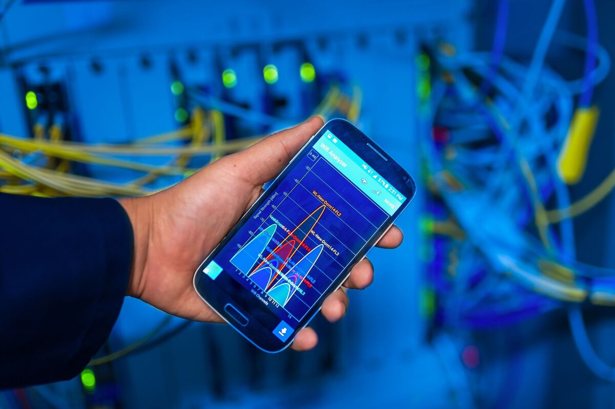 Pomiar parametrów sieci na telefonie przy szafie z okablowaniem