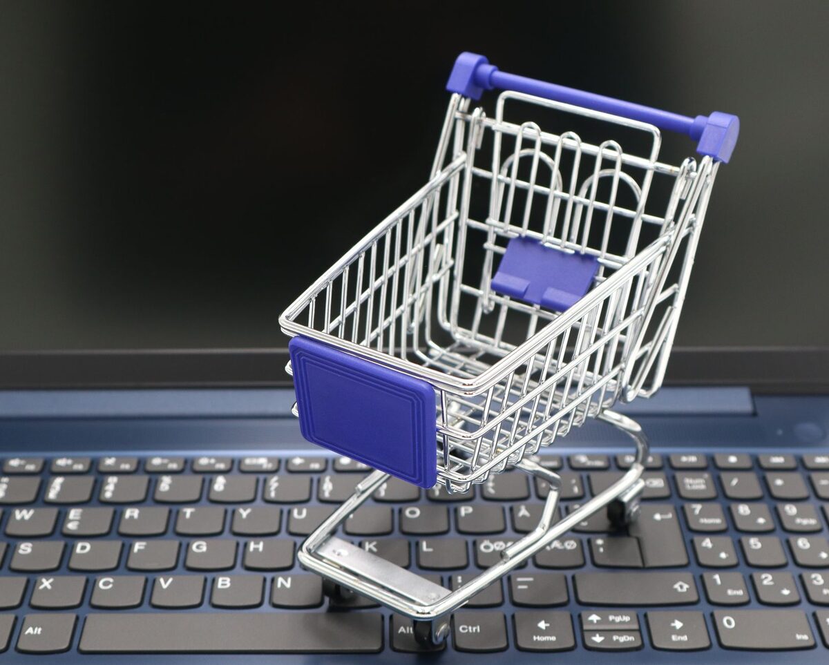 Miniaturowy wózek sklepowy na klawiaturze laptopa — sklep internetowy