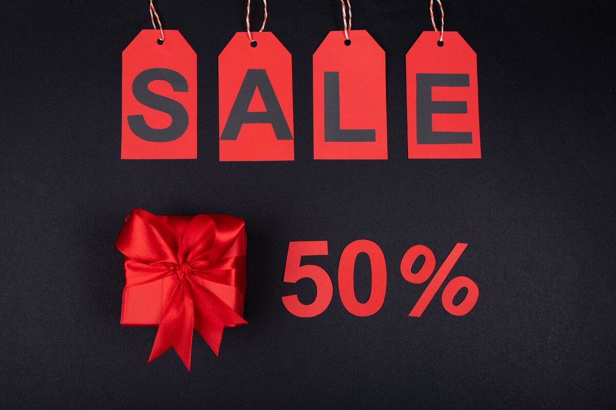Zawieszki z napisem SALE obok czerwonej kokardy